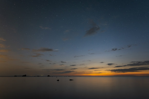 夜景，波罗的海平静，星空璀璨，地平线上朝向芬兰的云彩在日落后被阳光照亮。图片下载