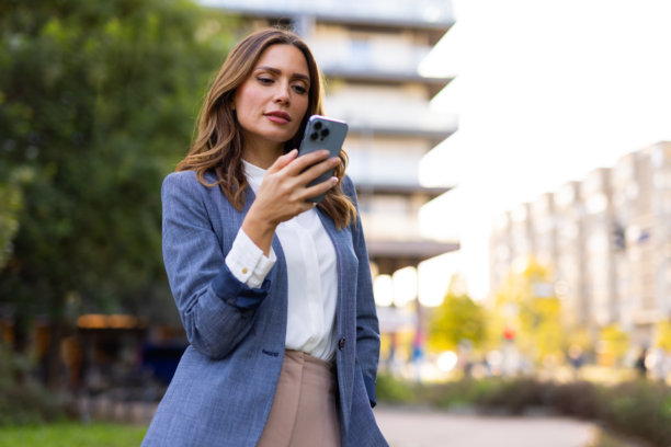 户外使用手机的活跃中年妇女图片下载