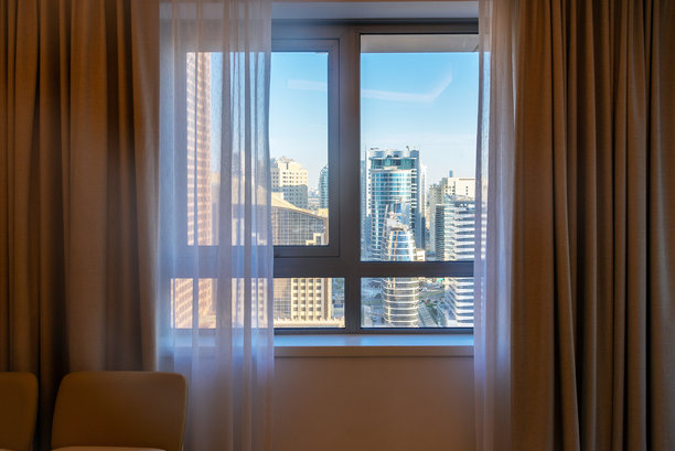 通过卧室窗户俯瞰现代新建筑的城市景观，迪拜，阿拉伯联合酋长国图片下载