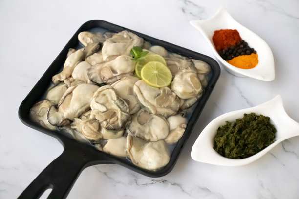 新鲜生蚝肉的特写镜头，展示其自然透明的质地。非常适合烹饪照片、海鲜促销或美食菜肴，强调海洋新鲜的品质。留白。Kalwa图片下载