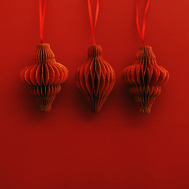 节日红色纸质圣诞装饰，三个悬挂的红色手电筒或灯笼，蜂窝状斯堪的纳维亚风格装饰，红色背景，简约单色照片，节日假期，俯视图，留白空间图片下载