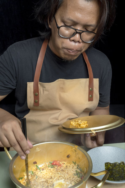 一个男人正在用筷子吃方便面图片下载