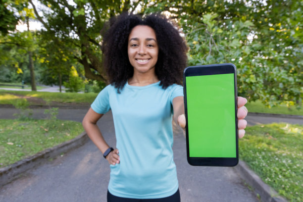非裔美国女运动员在户外健身课上展示绿屏智能手机图片下载