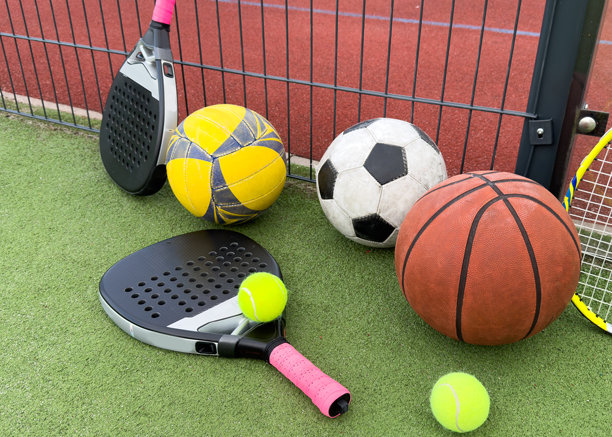 运动场上的一套各种各样的运动用球。一个大的橙色篮球，一个小的黑白足球图片下载