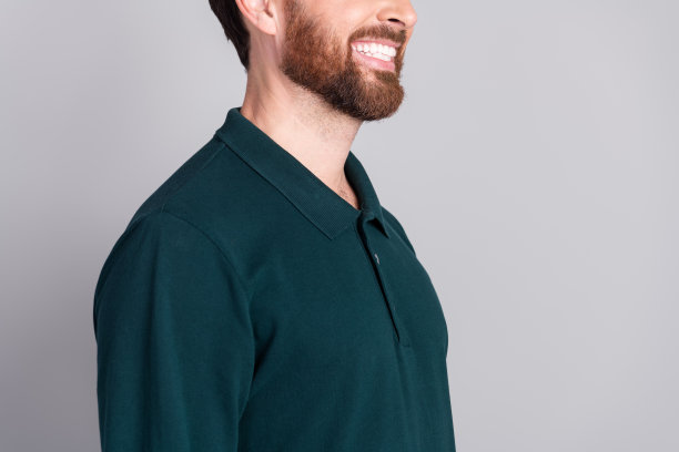 成功、迷人、积极的男性穿着时尚的绿色服装，背景为灰色。图片下载
