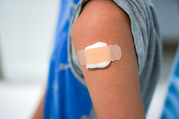 泰国清迈医院内，男孩上臂接种流感疫苗后，绷带和纱布的特写照片。图片下载