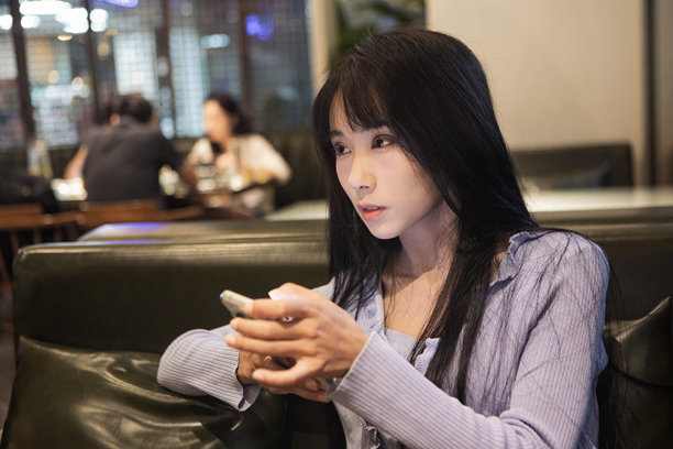 一个女孩在餐厅里拿着手机图片下载