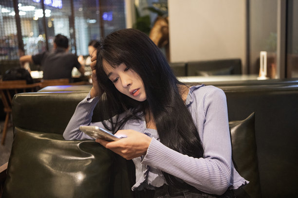 一个女孩在餐厅里拿着手机图片下载