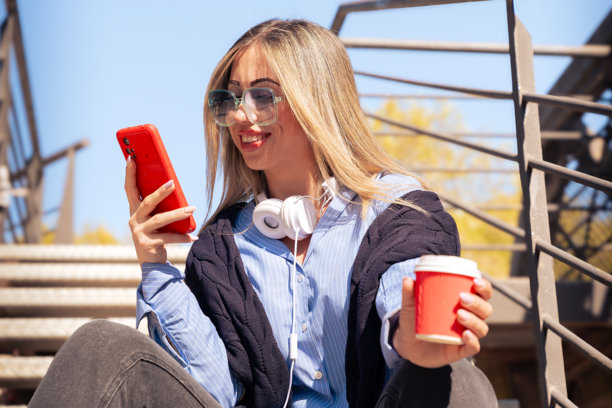 美丽的白人女性正在用智能手机上网。图片下载