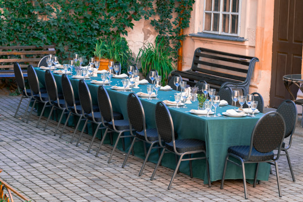 夏季城市咖啡馆露台上，桌子上摆放着餐具和盘子，周围环境舒适，但没有人。图片下载