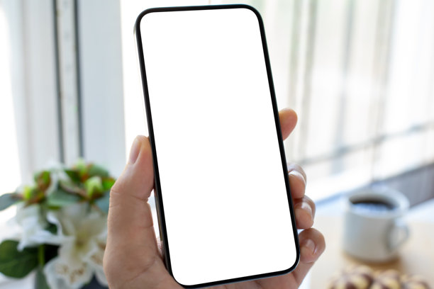 男性手握着手机，背景为白色咖啡馆的空白屏幕图片下载