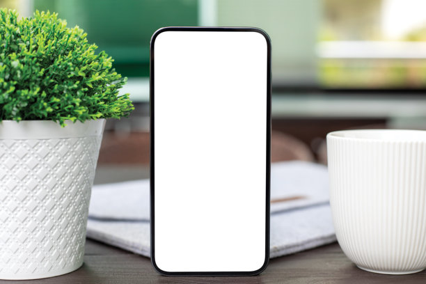 咖啡馆中木桌上的手机与孤立屏幕背景和杯子图片下载