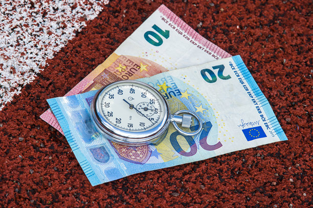 特写的秒表和纸币在田野上图片下载