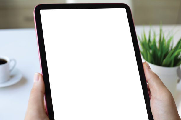 男性手握着带有独立屏幕的平板电脑，置于办公室中图片下载