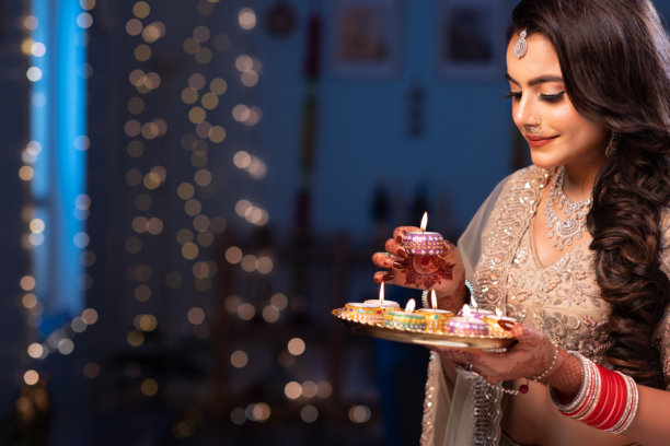 美丽的印度年轻印度教新娘在排灯节期间手持油灯照片图片下载