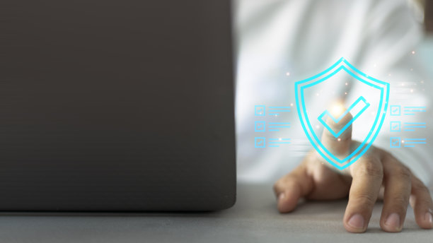 一个人正在触摸带有蓝色盾牌的笔记本电脑屏幕图片下载