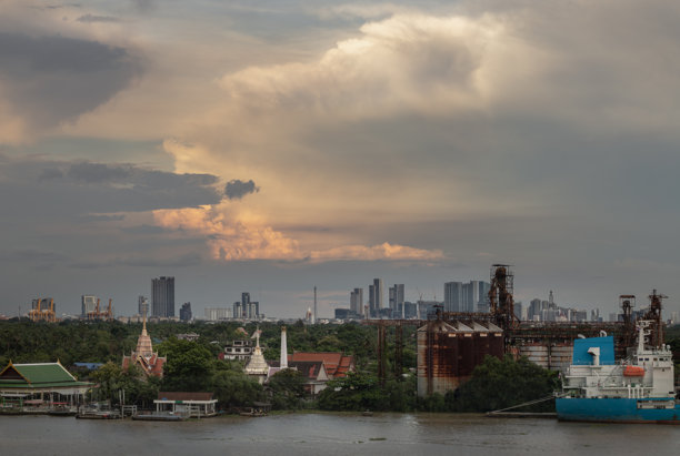 俯瞰查奥普拉雅河的绿色森林区，远处可见泰国寺庙、石油炼油厂和货船。图片下载