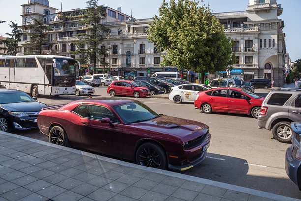 巴图米的街道上停着汽车。路边停着一辆酒红色的道奇挑战者。图片下载