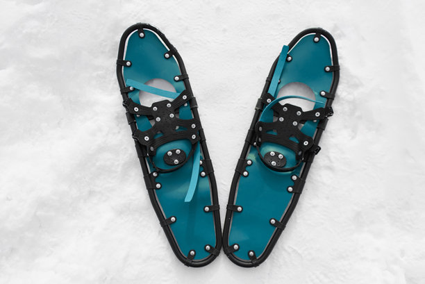 男子穿着雪鞋在雪地上行走图片下载