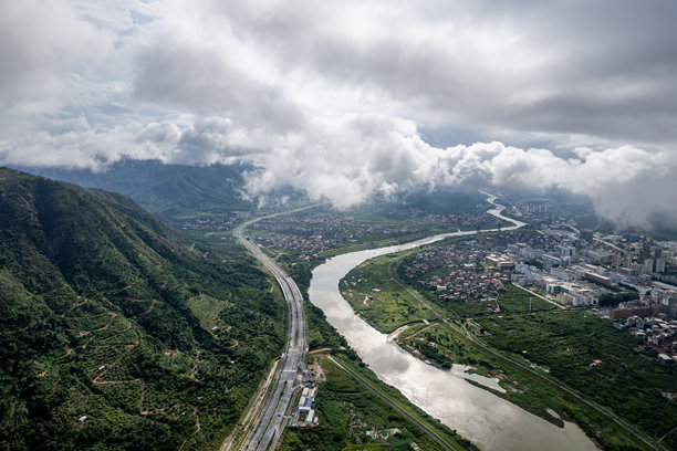 云雾缭绕的小镇上河流与建筑的鸟瞰图图片下载