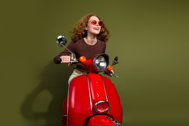 穿着棕色服装的年轻女士兴奋地驾驶滑板车，背景为空旷的卡其色。图片下载