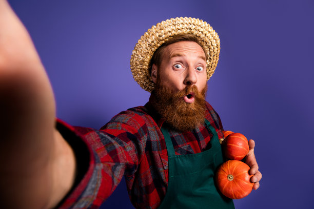 穿着格子衬衫的搞笑农民在紫色背景下庆祝感恩节收获季节的照片图片下载