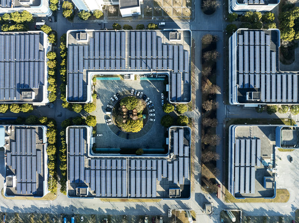 工厂屋顶和停车场上安装的太阳能电池板的鸟瞰图图片下载