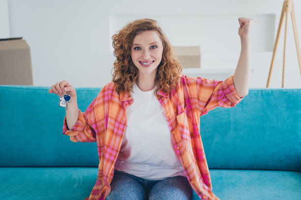 照片中快乐的女人买了新房子，在室内修复后安顿在舒适的公寓里图片下载