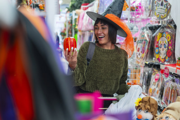女人在商场购买万圣节用品，以便在万圣节派对上使用图片下载