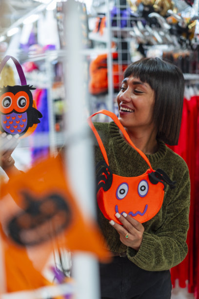 女人在商场购买万圣节用品，以便在万圣节派对上使用图片下载