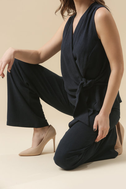 一系列年轻女性模特在深蓝色亚麻套装中的工作室照片，搭配裹身上衣和裤子。休闲而时尚的服装，春夏时尚潮流。图片下载