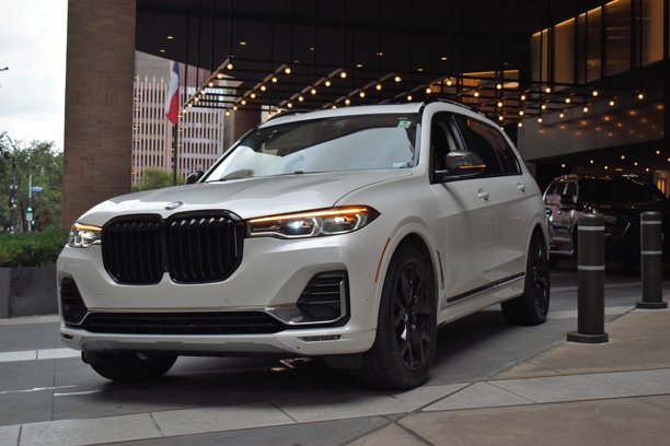 一辆白色宝马X7豪华SUV，停在市中心金融区的一家酒店前。图片下载