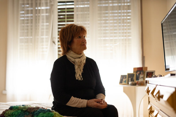 一位八十多岁老年女性坐在她的卧室里的人像图片下载