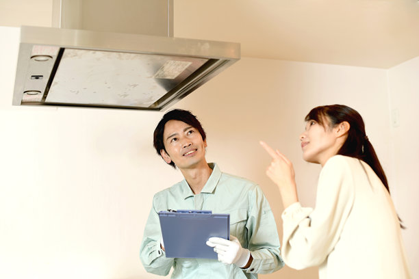 亚洲男性工作人员与女性顾客检查油烟机图片下载