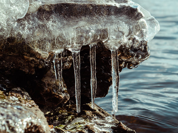 融化的冰块和冰柱躺在海岸上图片下载