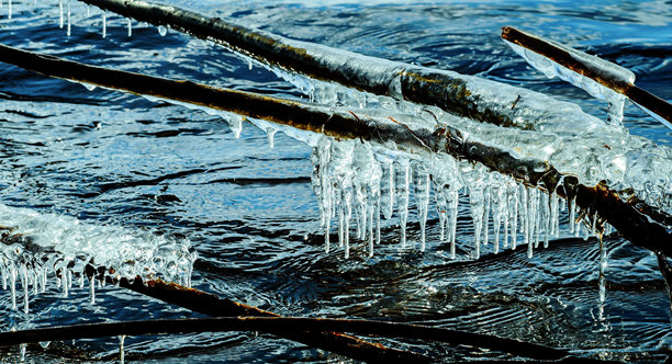 融化的冰块和冰柱躺在海岸上图片下载