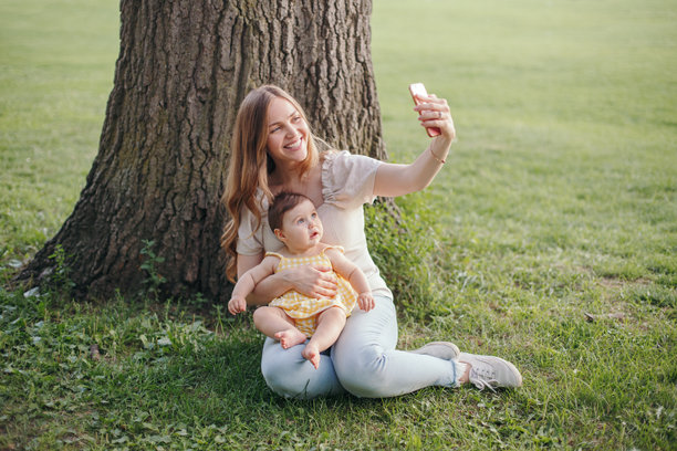 中年白人母亲与女儿幼童用智能手机拍自拍照图片下载