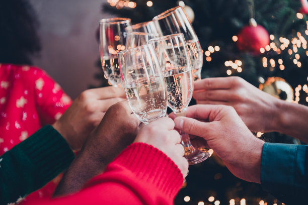 吸引人的年轻人举杯庆祝，办公室内的新年装饰，企业派对的裁剪照片图片下载