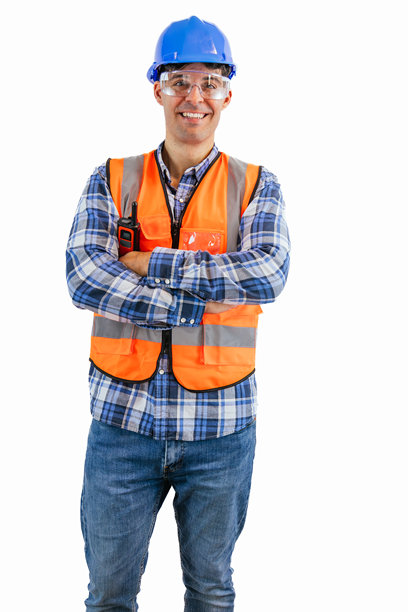 微笑的建筑工人竖版照片：身穿橙色马甲和安全帽，双臂交叉图片下载
