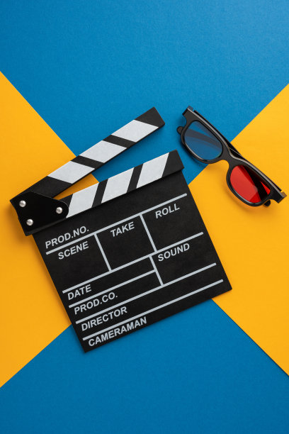 概念性的垂直图像，展示了电影拍板和3D眼镜，背景为鲜艳的蓝色和黄色。图片下载