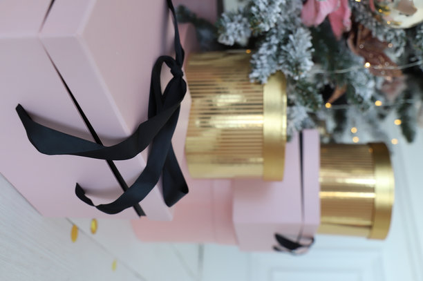 圣诞树下的地板上放着包裹好的圣诞礼物特写。图片下载