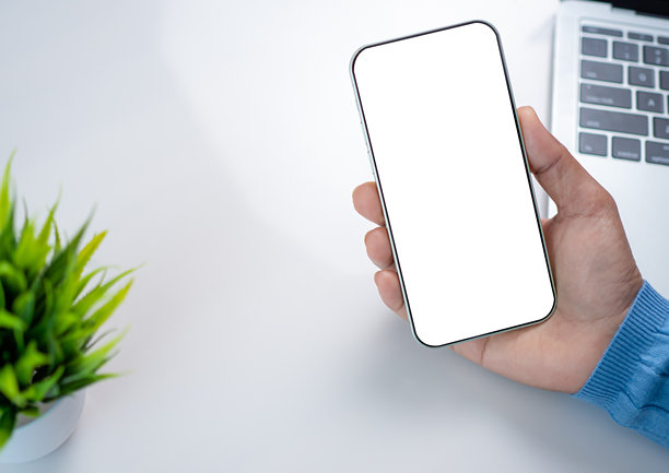 智能手机屏幕的模型图，手机上有空白文本区域，女性手持智能手机工作，白色背景适合广告、营销、设计和创意工作空间。图片下载