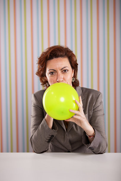 女商人在办公室吹气球图片下载