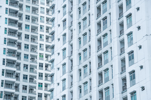 雅加达北部Pluit区的高层住宅楼低角度照片，背景是明亮的天空，留有空白文字区域图片下载