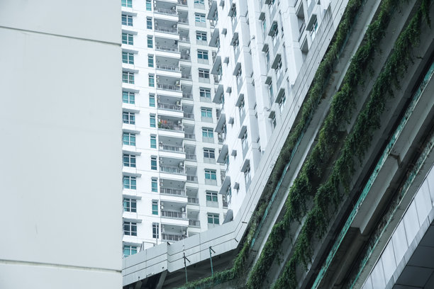 雅加达北部Pluit区的高层住宅楼低角度照片，背景是明亮的天空，留有空白文字区域图片下载