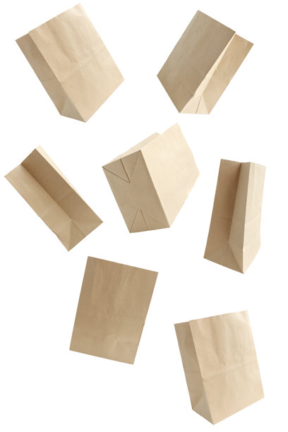 多种不同的开放牛皮纸袋在白色背景上掉落。图片下载