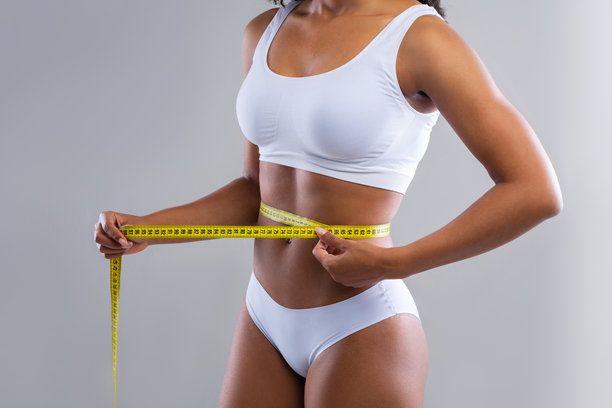 穿着白色内衣的黑人女性在测量自己的身体图片下载