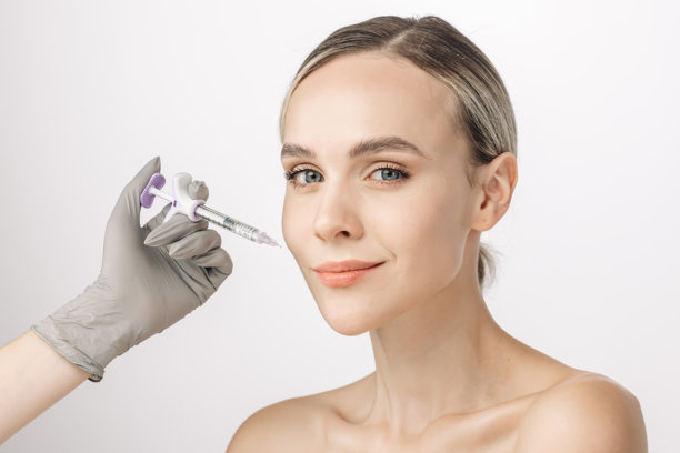 一位女性自信地在白色背景前摆姿势，旁边放着一支注射器。这张图片捕捉了美容服务的本质，突显了自我护理和皮肤健康的重要性。图片下载