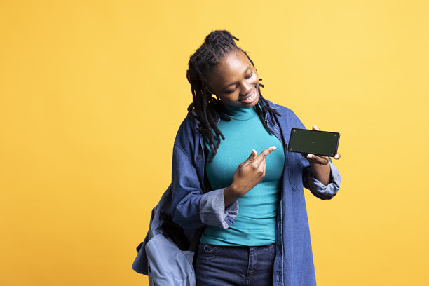 女性手持用于品牌广告的色键智能手机，背景为摄影棚图片下载