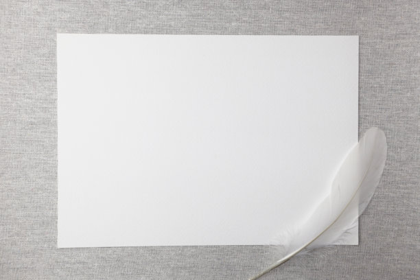米色背景上的白色空白纸张与羽毛。图片下载